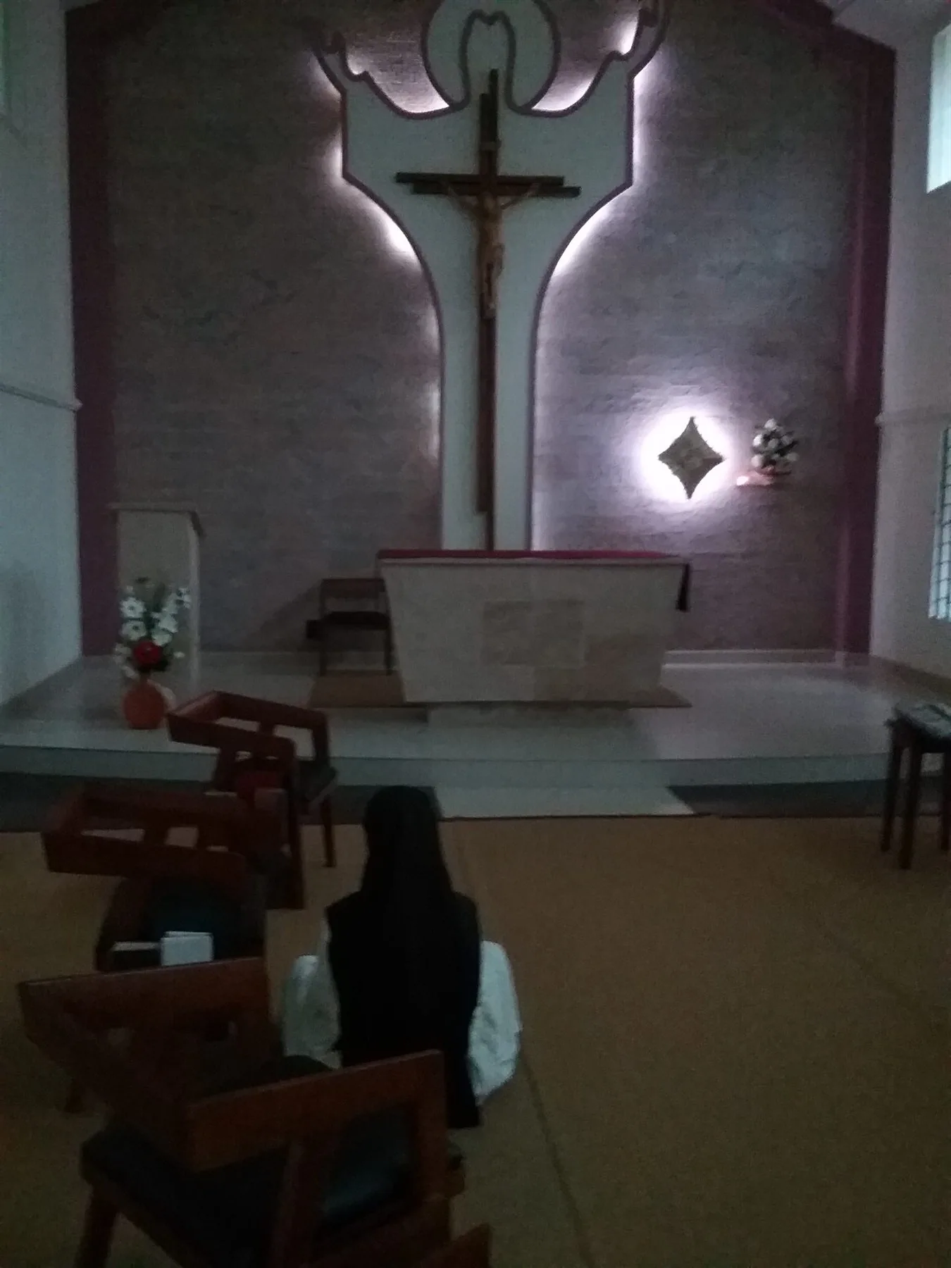A sister praying before the altar in the chapel
